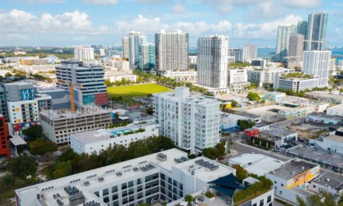 Drone image of buildings in a Miami neighborhood with Biscayne Bay in the background