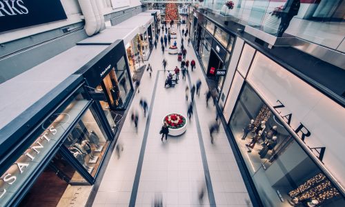 Image of a shopping mall with blurred people walking by
