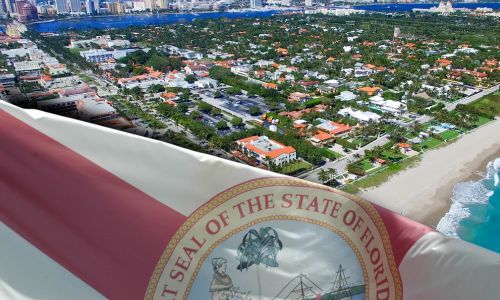 Photo illustration of the Florida State Flag over an aerial view of a beach in Palm Beach to illustrate New Proposed Rules for Implementing SB 264