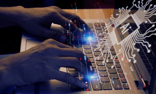 Hands typing on a laptop keyboard overlaid with a digital circuit and AI microchip graphic, symbolizing artificial intelligence technology in action.