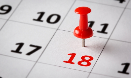 Calendar with the date 18th highlighted by a red pushpin