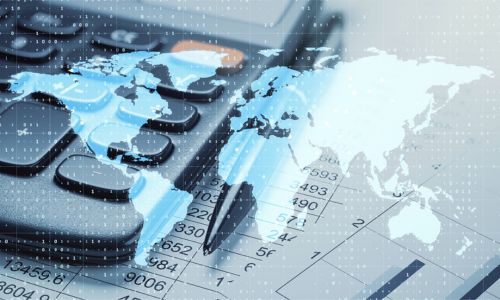 A digital composite image of a world map overlaid on a calculator, financial documents, and a pen, symbolizing international tax and finance.